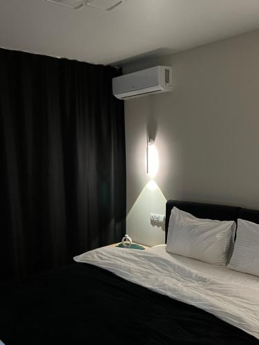 a bedroom with a bed with a light on the wall at Wood Нова затишна 2-кімнатна квартира in Ternopilʼ