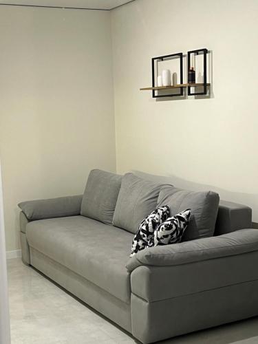 a gray couch in a living room with a shelf at Wood Нова затишна 2-кімнатна квартира in Ternopilʼ