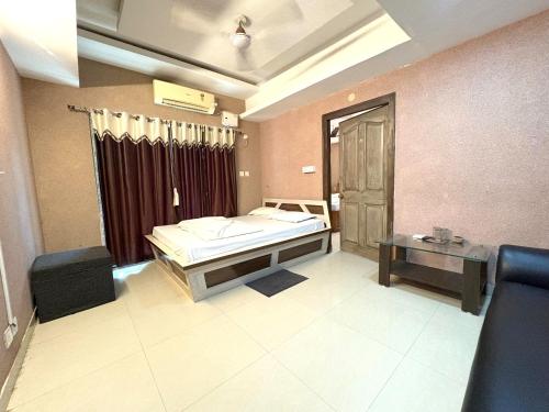 a bedroom with a bed and a table and a window at Sea Sand Digha in Digha