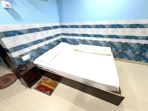 a bed in a room next to a wall at Sea Sand Digha in Digha