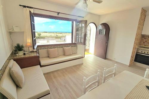 a living room with a couch and a large window at Apartamento con terraza y vistas al mar en Son Bou in Son Bou
