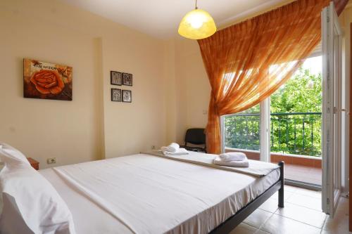 a bedroom with a bed and a large window at Sunset's Nest by Golden Host in Flogita