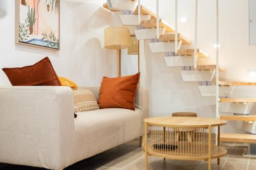 - un salon avec un canapé blanc et une table en bois dans l'établissement L'écrin de la Seine, à Andrésy