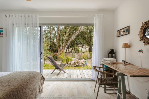 - une chambre avec un lit, un bureau et une porte coulissante en verre dans l'établissement Villa Magiscla, à Dolus-d'Oléron