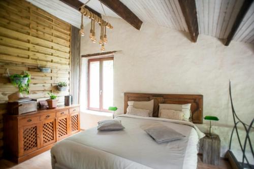 une chambre avec un grand lit et une fenêtre dans l'établissement 13Th Century Cévennes Stone House In Nature, à Soustelle