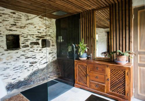 La salle de bains est pourvue d'une douche en verre et d'une commode en bois. dans l'établissement 13Th Century Cévennes Stone House In Nature, à Soustelle