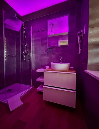 a bathroom with a sink and a shower with purple lighting at Apartament "Love Heaven" Jacuzzi SPA z dużą wanną z hydromasażem dla Dwojga in Gniezno