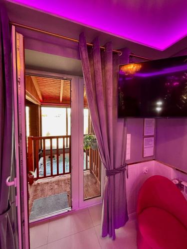a living room with a purple ceiling and a tv at Apartament "Love Heaven" Jacuzzi SPA z dużą wanną z hydromasażem dla Dwojga in Gniezno