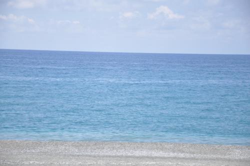 una persona parada en una playa cerca del océano en B&B Fronte mare, en Belmonte Calabro