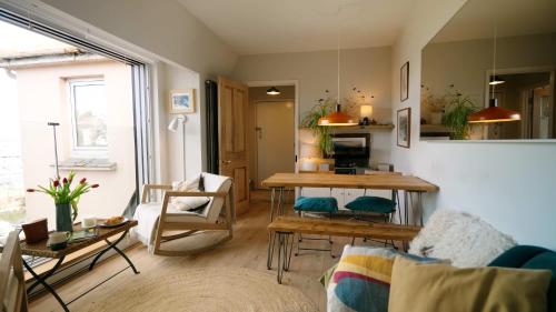 a living room with a table and a couch at Breathtaking Harbourside Views With Parking at 'Harbour Strand' in Falmouth