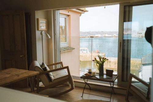 a living room with a view of the water at Breathtaking Harbourside Views With Parking at 'Harbour Strand' in Falmouth