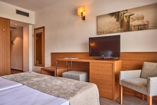 a hotel room with a flat screen tv and a bed at Hotel Playa Golf - Adults Only in Playa de Palma