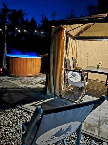 a tent with a table and chairs in front of it at Leśne zacisze - dom z kominkiem i balią in Jordanów