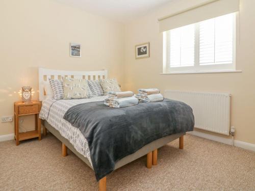 a bedroom with a bed with two pillows on it at Malting Cottage in Dawlish