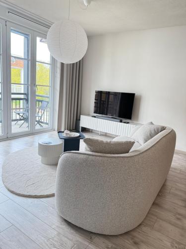 a living room with a couch and a tv at Appartement Duinhof, Cadzand-Bad in Cadzand-Bad