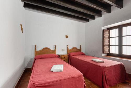 2 posti letto in una camera con lenzuola rosse di La Casa Grande a Málaga