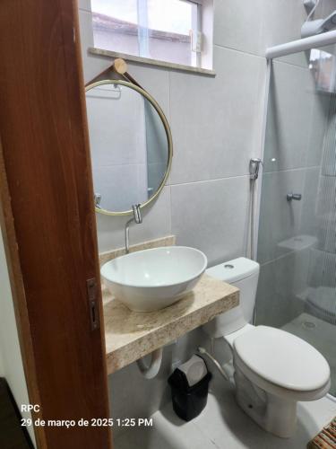 a bathroom with a sink and a toilet and a mirror at Casa Nova Temporada Barreirinhas Lençóis Maranhense in Barreirinhas