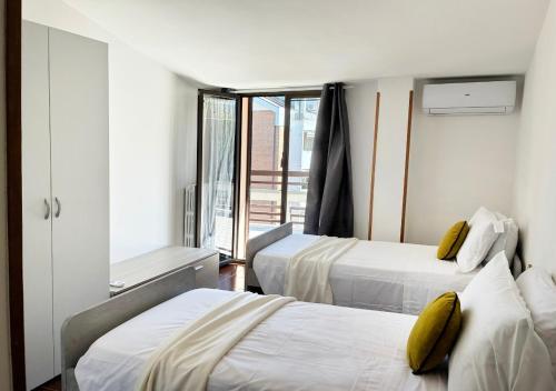 a hotel room with two beds and a window at Holihome MENTANA FRN in Alba Adriatica