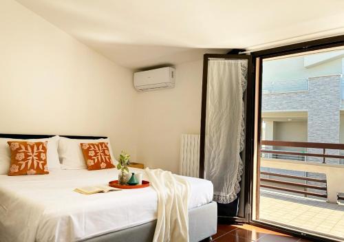 a bedroom with two beds and a balcony at Holihome MENTANA FRN in Alba Adriatica