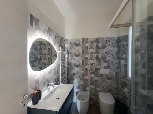 a bathroom with a sink and a mirror and a toilet at Casa Bianca, Vista unica sul lago di Como in Dervio