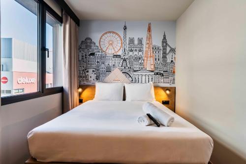 a bedroom with a large white bed with a large window at easyHotel Madrid Alcala in Madrid