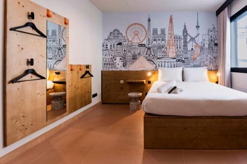 a bedroom with a bed and a wall with a city at easyHotel Madrid Alcala in Madrid