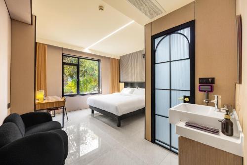 a room with a bed and a sink and a bedroom at Shanghai Zhuzhu Hotel - 24-hour free airport pick-up and drop-off at Pudong Airport in Shanghai