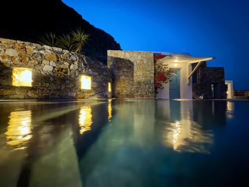 a villa with a swimming pool at night at Villa Mikros Vorias in Karavostasi