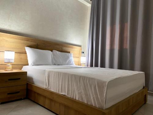 a bedroom with a large bed with a wooden headboard at Razan's Cozy Corner in Agadir
