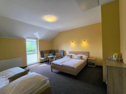 a bedroom with two beds and a table and chairs at Willa Global komfortowe pokoje nad morzem in Jastrzębia Góra