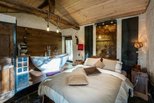 une chambre avec un lit et une baignoire dans l'établissement 13Th Century Cévennes Farmhouse With Natural Pool, à Soustelle