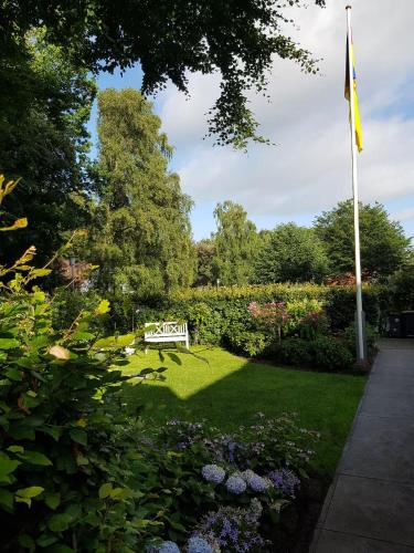 a bench in the middle of a garden with a flag at Schoen - Ferienwohnung Glücksand in Sandwig