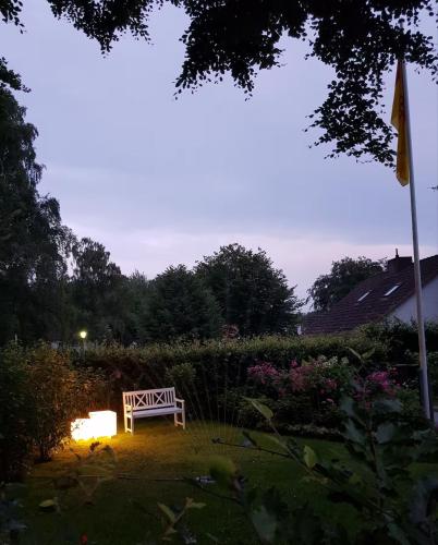 a bench sitting in the middle of a yard at Schoen - Ferienwohnung Glücksand in Sandwig
