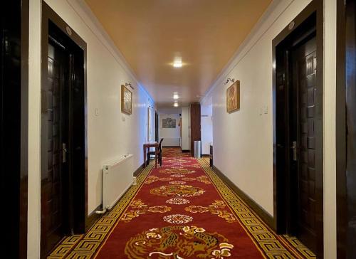 a hallway with two doors and a rug on the floor at The Highland Mountain Resort & Spa Kargil in Kargil