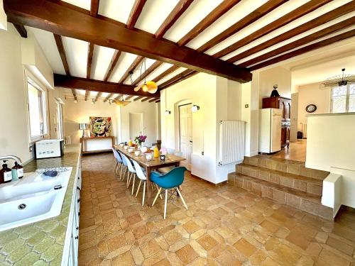 Una cocina grande con una mesa y una bañera. en La Villa Dorange, en Sailly-Flibeaucourt