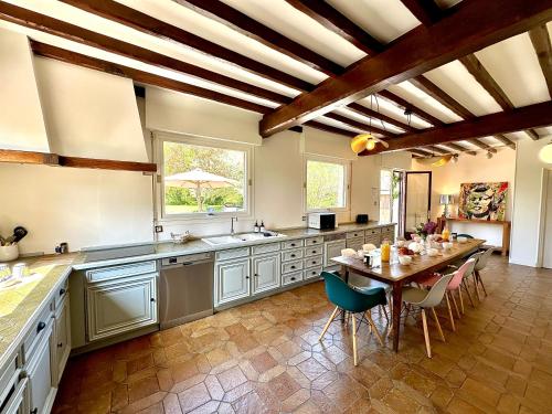 Una gran cocina con mesa y comedor. en La Villa Dorange, en Sailly-Flibeaucourt