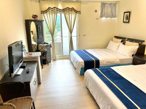 a hotel room with two beds and a television at 清馨茶園民宿 in Datong