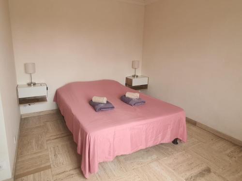 - un lit rose dans une chambre avec deux lampes dans l'établissement LES MOUETTES A, à Cannes