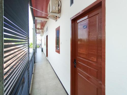 a hallway with a door and a walk way at Ghe Ai Homestay RedPartner in Tulungagung