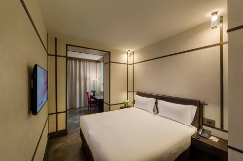 a hotel room with a bed and a television at Hotel Balestri - WTB Hotels in Florence