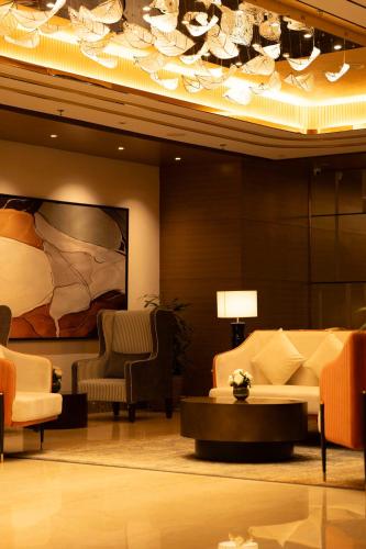 a lobby with a couch and a table and chairs at Radisson Blu Pune Hinjawadi in Pune