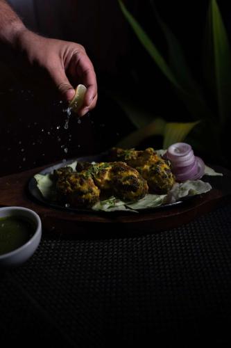 a person is sprinkling food on a plate of food at Radisson Blu Pune Hinjawadi in Pune