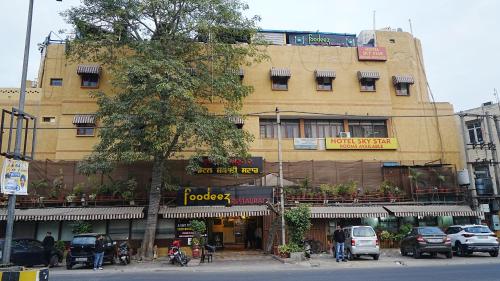 a building on a street with cars parked in front of it at Sky Star Hotel in Amritsar