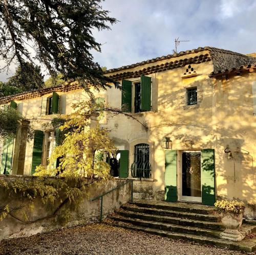 an old white house with green shutters and stairs at Mas de Monge in Tarascon