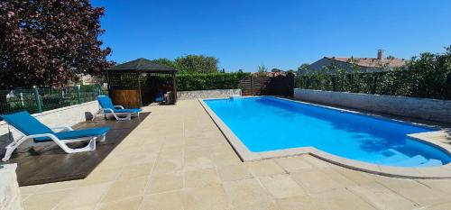 une piscine avec deux chaises et un gazebo dans l'établissement L'étape, à Les Gonds