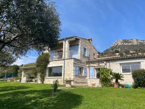 a large stone house on a green lawn at La Marjalou à Vence avec piscine & grand jardin in Vence