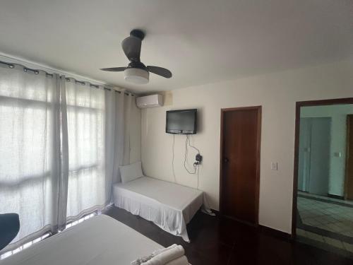 a room with a bed and a ceiling fan at Bueno completo Ar split, Tv a cabo, Wi-Fi Ultra e estacionamento privativo na melhor localização de Goiânia! in Goiânia