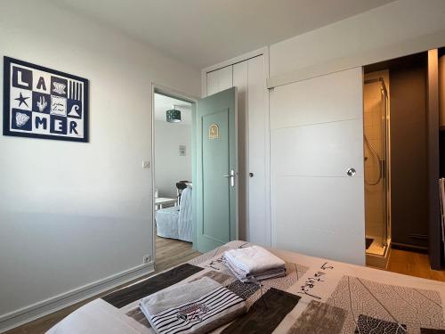 a bedroom with a bed and a mirror at L'appart Lutin du bord de mer in Luc-sur-Mer