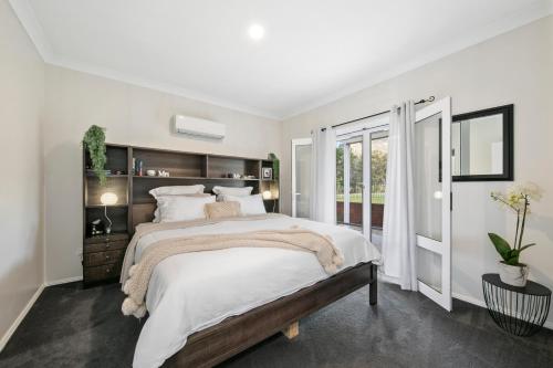Un dormitorio blanco con una cama grande y una ventana. en Little Corner Farm, en Broke