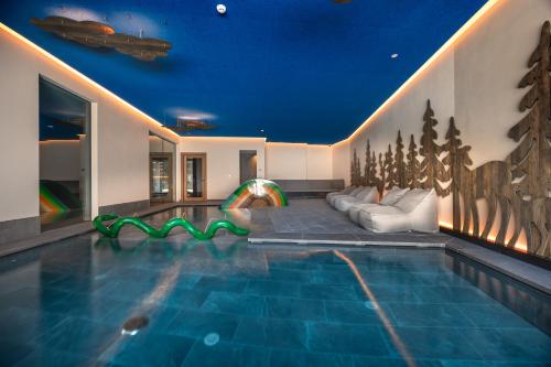 a house with a swimming pool with a couch at Hotel Vioz in Peio Fonti
